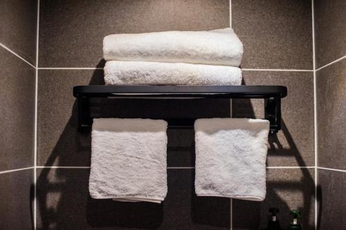 a group of towels on a rack in a bathroom at Fenghuang Sulv Yunzhu River View Homestay in Fenghuang