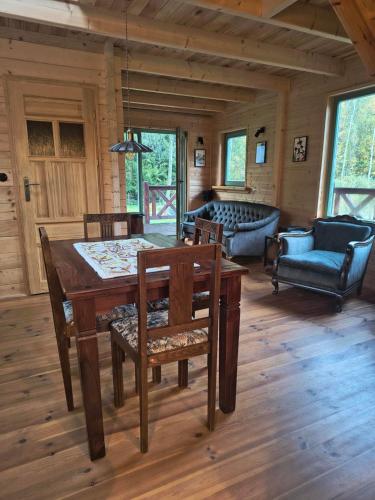 ein Wohnzimmer mit Tisch und Stühlen und einer Couch in der Unterkunft Ogród Shinrin Yoku (Haru) Odpoczynek w Lesie in Srokowo