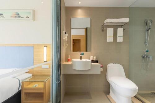 ein Badezimmer mit Toilette, Waschbecken und Dusche in der Unterkunft City Comfort Inn Baise Uprising Memorial Park Laiyu in Qitang