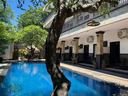 ein Baum mitten im Swimmingpool in der Unterkunft Tendan Residence Hotel in Legian