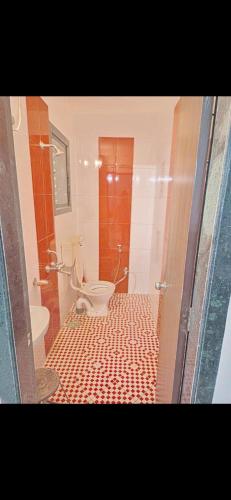 a bathroom with a toilet and a shower with a tile floor at Bungalow in Lonavala
