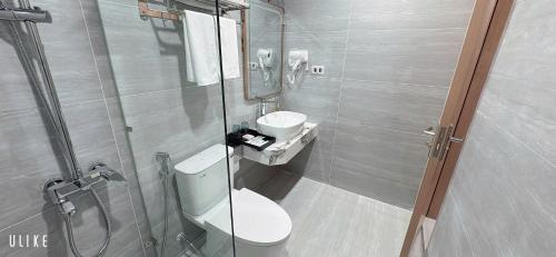 a bathroom with a toilet and a sink and a shower at One Villa Hotel 6 in Long Biên