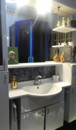 a bathroom with a white sink and a mirror at Villa Promentilla in Inosloban