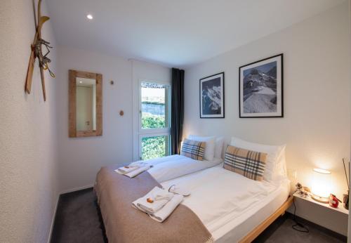 a bedroom with a large bed with a window at Chalet Silence in Wengen