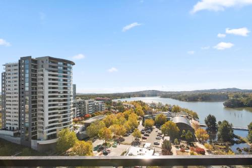 an aerial view of a large apartment building and a river at Sleek 2-Bed Apartment with Rooftop Garden Access in Belconnen