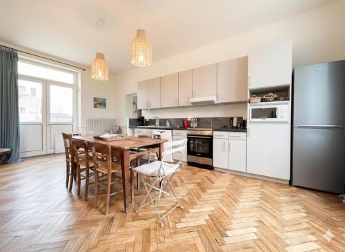 eine Küche mit Holztisch und Kühlschrank in der Unterkunft Ancien presbytère, grand jardin, proche Argentan et forêt, 8-9p in Sévigny