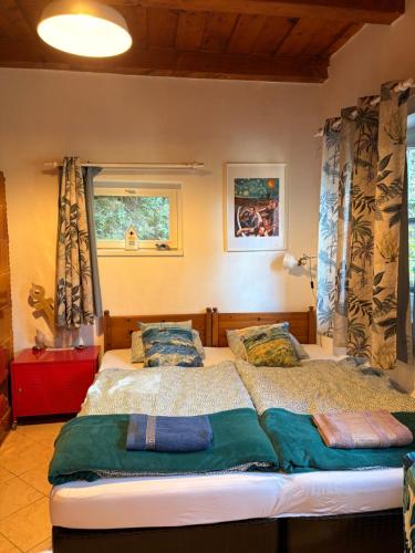 a bedroom with a large bed and a window at Palócliget Vendégház in Kétbodony