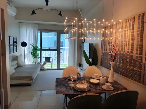 马尼拉Modern 1BR With Magnificant Bayview Garden View, Near Airports, Okada, Solaire with Free Parking的客厅配有餐桌和吊灯。