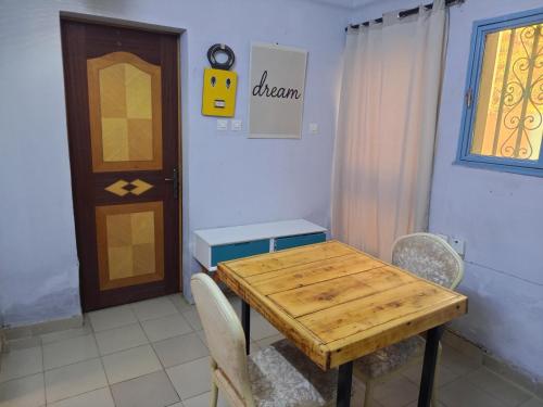 a dining room with a wooden table and chairs at La Petite Maison in Ouagadougou