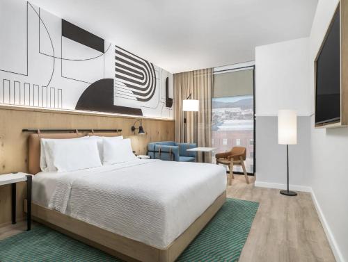 a hotel room with a bed and a desk at Caption By Hyatt Chattanooga Downtown in Chattanooga