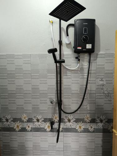 a shower in a bathroom with a hose attached to the wall at Idaman Homestay Ayer Tawar Tok Bali in Pasir Puteh