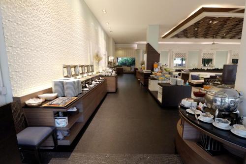 a restaurant with a buffet line with dishes on display at Methavalai Hotel in Cha Am
