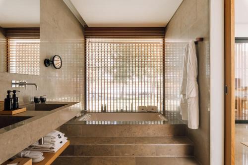 a bathroom with a tub and a sink at L'AND Vineyards - Relais & Châteaux in Montemor-o-Novo