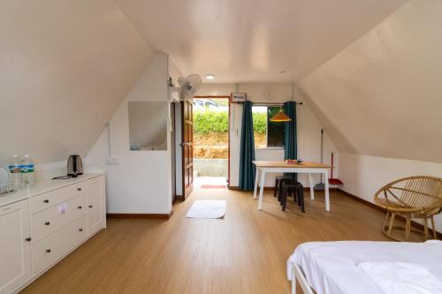 a room with a bed and a table and a kitchen at Kanso Hill Lowii Cottage in Kampong Kundassan