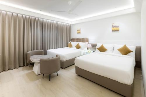 a hotel room with two beds and a desk at Emerald Luxe A Boutique Hotel in Sohāna