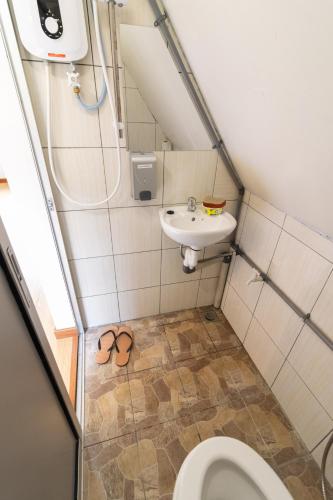 a small bathroom with a toilet and a sink at Kanso Hill Lowii Cottage in Kampong Kundassan