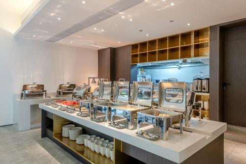 uma cozinha com vários pratos em uma bancada em REZEN LONGUU Hotel Guangzhou Baiyun International Airport em Huadu