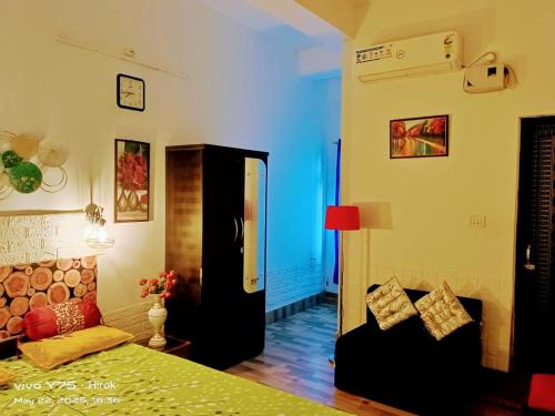 a bedroom with a bed and a couch at Hotel Baruah Tower in Tezpur