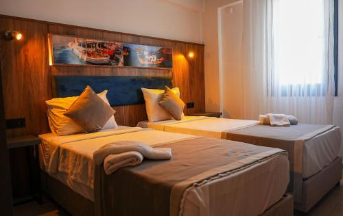a hotel room with two beds with towels on them at Smart City Suites Hotel Bodrum in Bodrum City