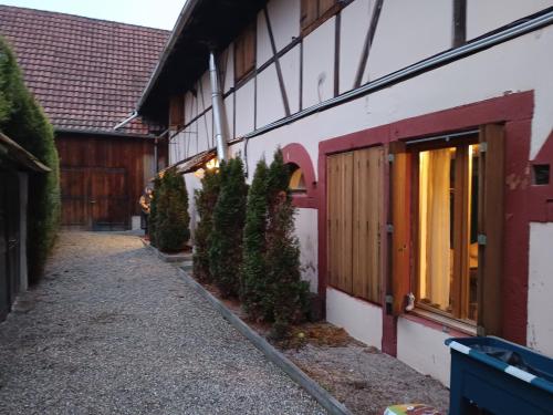 Una pasarela junto a un edificio con árboles a un lado. en Maisonnette proche de Strasbourg, en Vendenheim