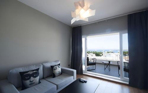 a living room with a couch and a large window at Smart City Suites Hotel Bodrum in Bodrum City