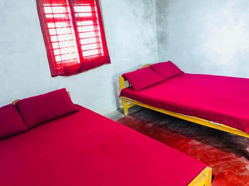 two beds in a room with red sheets and a window at Delft Aquatic Tourist Hotel in Delft Centre