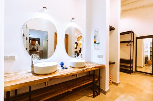 达赫拉Dakhla Attitude的浴室里有两个洗手池和一面镜子