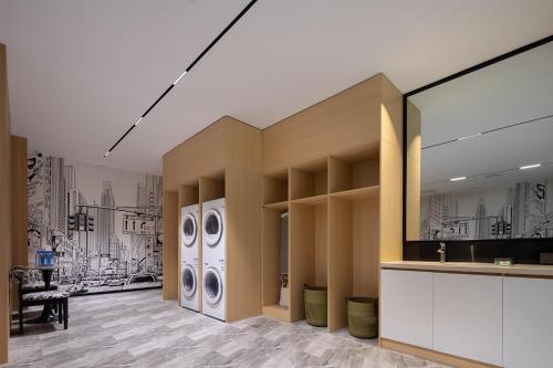 a room with a hallway with washing machines at Fengqi Wutong Holiday Hotel - Changsha Wuyi Avenue Railway Station Metro Station Branch in Changsha