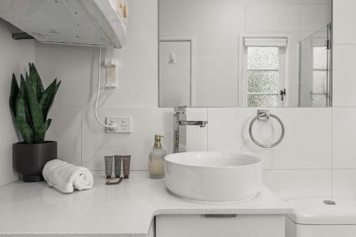 ein weißes Badezimmer mit Waschbecken und Spiegel in der Unterkunft Charming 1 Bed Cottage with Garden Retreat in Bald Hills