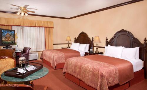 a hotel room with two beds and a television at Folk Inn Ontario Airport in Ontario