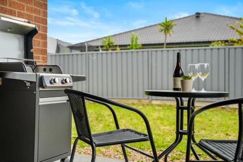a patio with a table with a stove and wine glasses at Seednest BBQ Cozy Family house in Alfredton