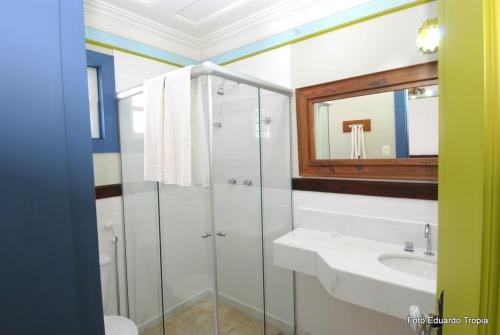 W łazience znajduje się prysznic, umywalka i lustro. w obiekcie Pousada Laços de Minas w mieście Ouro Preto