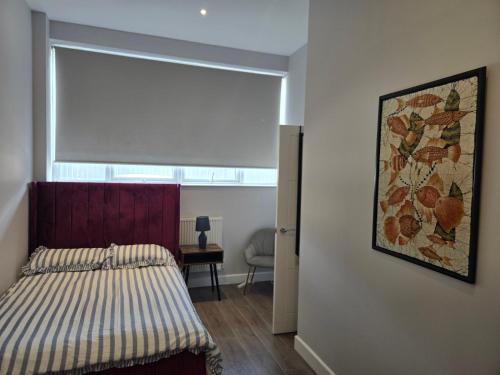 a bedroom with a bed and a painting on the wall at Chris cosy retreat in Buckinghamshire