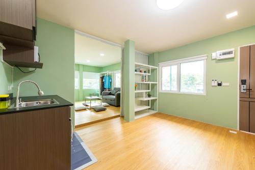 an empty kitchen and living room with green walls at GL Sport Club Serviced Residence in Bangkok