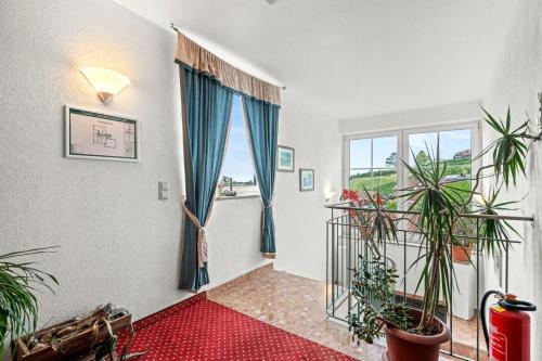 a living room with potted plants and a window at Landgasthof Rössle in Kressbronn am Bodensee