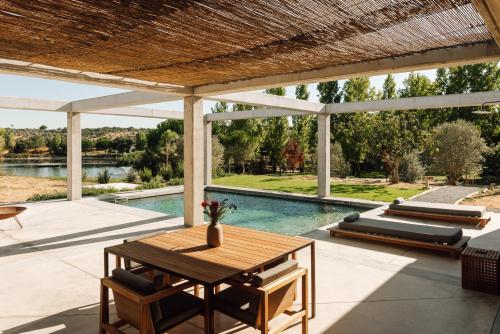a patio with a table and a swimming pool at L'AND Vineyards - Relais & Châteaux in Montemor-o-Novo