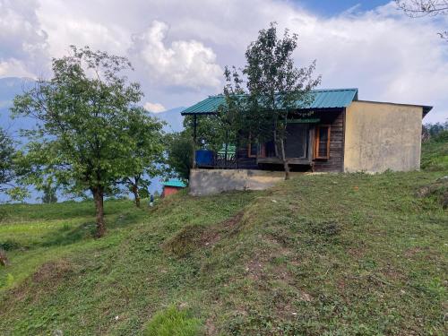 ein kleines Haus auf einem Hügel in der Unterkunft The Goat Village in Bhatwāri
