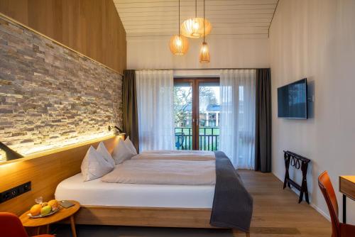 ErmatingenLILIENBERG的一间带床和砖墙的卧室