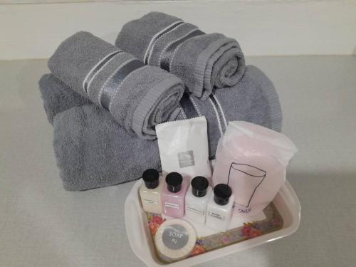 バンバンセーンにあるสินอนันต์ อพาร์ทเม้นต์Sinanan apartmentのテーブルの上に化粧品とタオルが置かれたトレイ