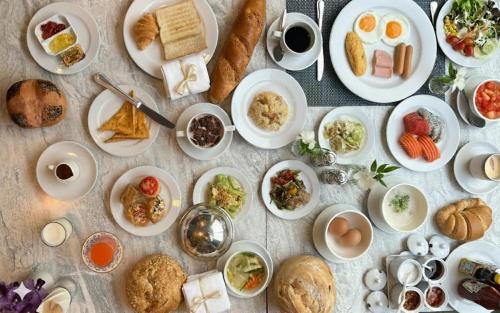 una mesa llena de platos de comida con huevos y pan en The Maruay Garden Hotel, en Bangkok