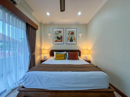 a bedroom with a bed with two lamps and a window at View Talay Longstay in Jomtien Beach