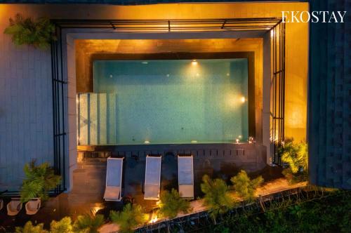 a swimming pool on the side of a building at EKOSTAY Gold - AshBee Villa in Kīhīm