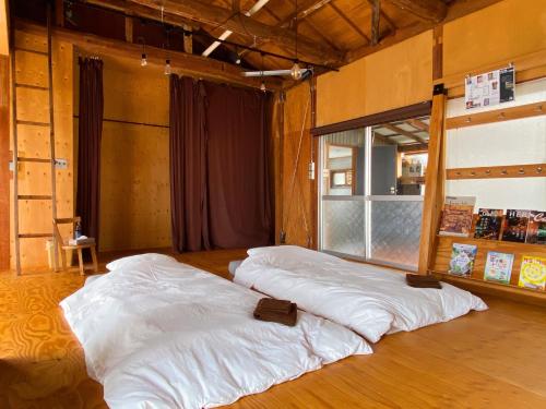 2 camas blancas grandes en una habitación con ventana en コワーキングスペース kuzume Base ゲストハウス 古朴-MOKU-1棟貸の宿, en Konan