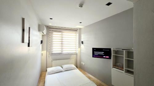a white room with a bed and a tv on the wall at 3A House - Sultanahmet in Istanbul
