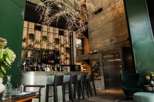 a bar with black chairs and a green wall at Boutique Hotel Herman K in Copenhagen
