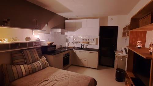 a small kitchen with a bed in a room at Gezellige studio met balkon - Santhooft centrum Nieuwpoort-bad in Nieuwpoort