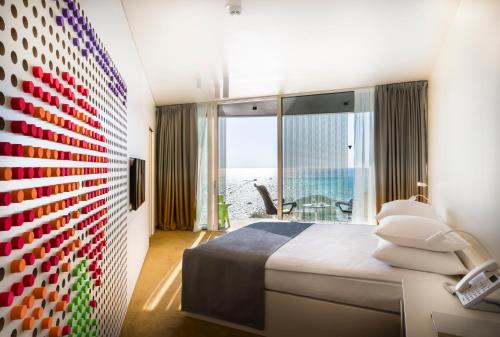 a bedroom with a large bed and a large window at Maistra Select Family Hotel Amarin in Rovinj