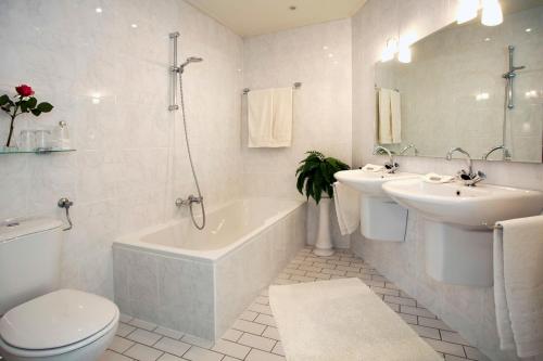 a bathroom with a tub and a toilet and a sink at Bed and Breakfast Holter in Enschede