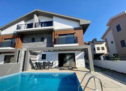 a house with a swimming pool in front of it at House of ALICE - Villa with Pool near Çalış Beach in Fethiye