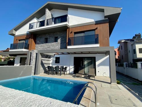 a house with a swimming pool in front of it at House of ALICE - Villa with Pool near Çalış Beach in Fethiye